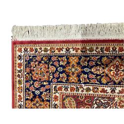 Persian design red ground rug, the field decorated with a central floral medallion and surrounded by alternating Boteh and palmette motifs, the guarded indigo border with repeating foliate patterns