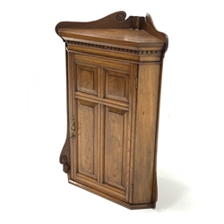 Georgian design oak wall hanging corner cupboard, raised back with incised scrolled detail over dentil cornice, four fielded panelled door enclosing two fixed shelves, W66cm