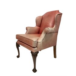 Georgian style wingback chair, newly upholstered in faded red studded leather, raised on leaf carved cabriole supports with ball and claw feet W80cm