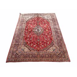 Large Kashan red ground carpet, the central field with medallion and interlaced trailing foliate enclosed by triple guarded border 291cm x 400cm