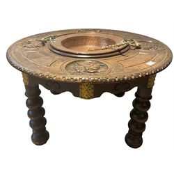 Carved oak brazier table, with one central copper dish, surrounded by top carved with masks, raised on turned supports 