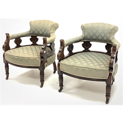  Pair late Victorian carved walnut framed tub shaped salon armchairs, upholstered in patterned green fabric, raised on turned supports and castors, W65cm  
