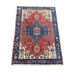 Turkish ground rug, blue lozenge medallion on red field with ivory spandrels and all over stylised floral and geometric design 135cm x 197cm