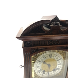 Late 19th century mantle clock in architectural walnut case, arched pediment with central leaf carved motif, enclosed by bevel glazed door, fluted and lunette carved, moulded base, brass dial decorated with floral scroll mounts, silvered Roman and Arabic chapter ring, twin train driven movement by 'Lenzkirch', stamped 'AUG 1 Million, 358398', striking the hours and half on single coil, with pendulum and key, H33cm, W22cm