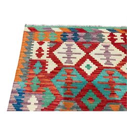 Anatolian Turkish Kilim multi-coloured rug, the crimson field decorated with all-over hexagonal lozenges of contrasting colours, enclosed by a multi-band border of geometric design