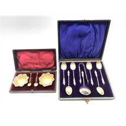 Set of six late Victorian 'Apostle' tea spoons with shell bowls, tongs and sifting spoon Birmingham 1898 Maker William Devenport, cased and a pair of silver circular salts with embossed and gilded decoration Chester 1899 Maker James Deakin & Sons, cased 