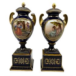 Pair of 'Vienna' porcelain urns and covers, each painted with classical scenes after Angelica Kauffman, signed A. Weh, against a cobalt blue ground with gilt scrollwork, H24cm (one a/f)