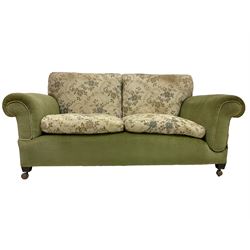 Early 20th century two seat drop arm sofa upholstered in green and floral fabric, terminating in shepherd castors