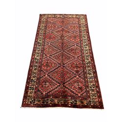 Persian Kurdish red ground rug, the central field with repeating lozenge design and bordered 300cm x 168cm