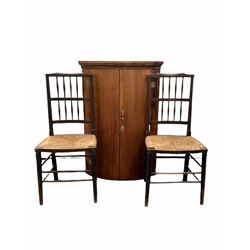 19th century mahogany bow front corner cupboard, together with a pair of spindle back dining chairs with string seats 