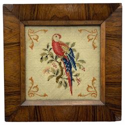 19th century woolwork picture depicting a parrot perched on a branch, within a square rosewood frame, 36.5cm x 36.5cm, together with a 19th century oval silk picture depicting a farmer in a landscape, within an oval gilt frame (2)