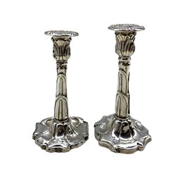 Pair of Edwardian silver candlesticks with leaf moulded sconces and shaped bases by Williams Ltd, Birmingham 1909 16.9oz H22.5cm max 