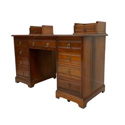 Edwardian walnut twin pedestal desk, two trinket drawers atop the rectangular top with moulded edge, fitted with central frieze drawer flanked by four graduating rawers to each side, carved with reeded detail, on ceramic castors