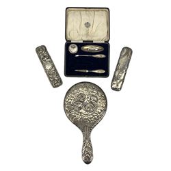 Silver backed hand mirror embossed with angel heads Chester 1907, two silver backed brushes and a silver part manicure set