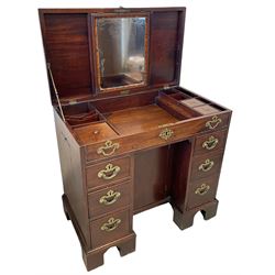 George III mahogany gentleman's kneehole dressing chest, rectangular hinged top concealing fitted interior with satinwood framed mirror, covered containers and open trays, over faux frieze drawer and six graduating drawers flanking the central cupboard, the sides flitted with twin sliding candle trays, lower moulded edge over bracket feet and castors

Provenance - property of a nobleman 
