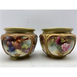 Two early 20th century Royal Worcester cache pots, of compressed form, each with four hand painted panels within gilt strapwork borders, the first decorated with roses, the second with autumnal berries and foliage, green printed marks beneath including shape number F132 and date codes for 1908 and 1909, H8.5cm (2)

