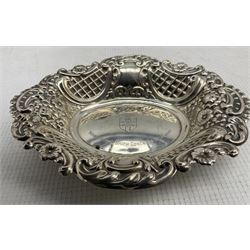 Modern silver bonbon dish with foliate, C scroll and lattice embossed sides, and personal engraving to centre, together with a silver mounted pocket watch stand, and two glass dressing table jars with silver covers