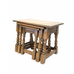 Early 20th century oak nest of three tables, each raised on turned and block supports 