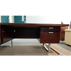 Prestige Range by Trevor Chinn for Gordon Russell - Mid century dark wood Executive desk, with pedestal fitted with two drawers and raised on chrome support, and an integrated sideboard, fitted with sliding doors enclosing shelf, Circa 1970s