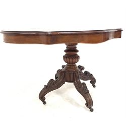 Victorian style mahogany centre table, the oval serpentine top over two drawers, raised on a lobe carved and turned column and four Victorian leaf carved and scrolled supports with castors 129cm x 78cm, H74cm