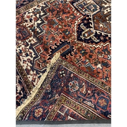 Persian Heriz red ground rug, geometric medallion on red field, decorated with stylised flower heads, 285cm x 199cm