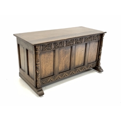 20th century medium oak blanket box with hinged top over floral carved frieze, four panel front and fluted and spiral turned pilasters 