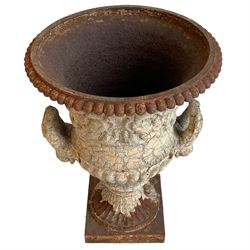 19th century cast iron Campana-shaped garden urn, the body decorated with putti and scrolls, gadroon cast underbelly with two heavy loop handles, on circular and fluted foot and square base, in thick crackled paint finish 