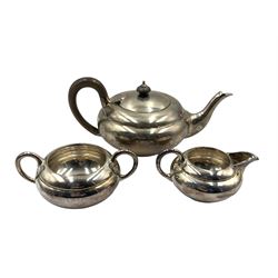 Silver three piece tea set of compressed circular design, the tea pot with stained handle and lift, London 1916 Maker C W Fletcher & Son Ltd 26.5oz gross 