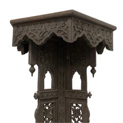 19th century carved hardwood Kashmiri plant stand or jardinier, hexagonal top with carved scrolling foliate decoration and flower heads, the tripod base with three protruding panels, each pierced with vine detail and archways with finials, the cabriole feet carved in the form of elephants with scrolling trunks