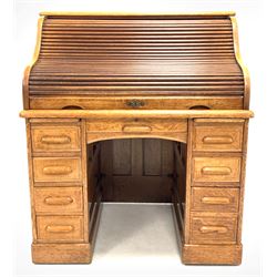 Early 20th century oak roll top desk, the waterfall tambour front sliding up to reveal interior fitted with drawers and correspondence shelves, two slides, one long and seven short drawers under, raised on castors, the lock stamped 'W.M.Richardson, Office furniture, Leeds & Bradford W106cm, H123m, D76cm

