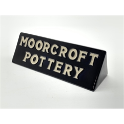 Moorcroft pottery shop display sign of triangular section, both sides reading 'Moorcroft Pottery' in white lettering on a black ground H5.5cm x L18cm   