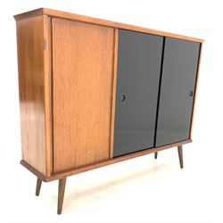 Mid 20th century teak and oak sideboard or bookcase, fitted with three sliding doors enclosing adjustable shelves, raised on turned supports, W109cm, H84cm, D27cm