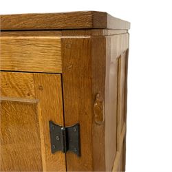 Rabbitman - oak bedside or lamp cupboard, adzed rectangular top over single panelled door with wrought metal latch and hinges, carved Rabbit signature, the interior fitted with divisions, by Peter Heap, Wetwang