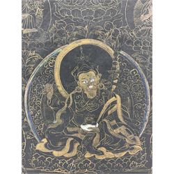 19th century black ground Tibetan Thangka, on cloth, painted in gilt and polychrome with Buddhist deities on foliate scroll ground, mounted on board, 74cm x 55cm 