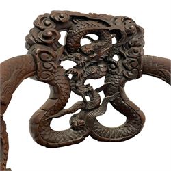 Japanese Meiji period open armchair, the back carved and pierced with dragon and scrolling scaled tails, projecting dragon carved arm terminals on scrolled supports, serpentine seat with decorative band, the apron and supports with scroll and chip-carved decoration