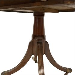Early 19th century mahogany Pembroke table, reeded drop-leaf rectangular top with rounded corners, fitted with single end drawer and opposing false drawer, on turned pedestal with four splayed reeded supports, cast brass paw castors
Provenance: From the Estate of the late Dowager Lady St Oswald