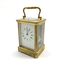  Early 20th century brass and bevelled glass carriage clock, white enamel dial with Arabic and Roman numerals, twin train driven movement striking the hours and half on coil, the back plate stamped '394', H15cm (not including handle upright)   