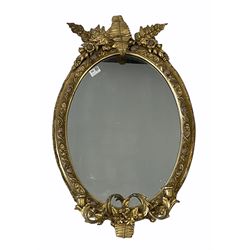 19th century giltwood and gesso girandole oval wall mirror, with leaf pediment, floral moulded frame and two candle sconces 53cm x 84cm