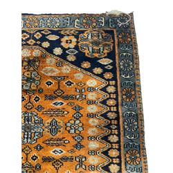 Small Persian rug or mat, extending rust ground field decorated with small stylised motifs, each corner with Gul motifs, trailing stylised flower heads
