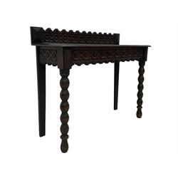 Late 19th century gothic revival oak side table the raised back carved with repeating rosette and fleur-de-lis motifs, the rectangular top with moulded edge, the apron with matching decoration, raised on bobbin turned supports 