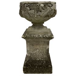Reconstituted urn, decorated with swags on a composite plinth