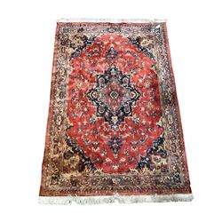 Persian design red ground rug, the central field decorated with stylised foliate 184cm x 285cm