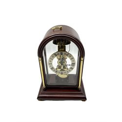 Contemporary Hermle 8-day mantle clock - in a round toped fully glazed case on a rectangular plinth raised on bun feet, skeletonised single train movement with a recoil anchor escapement and passing strike on the hour.
