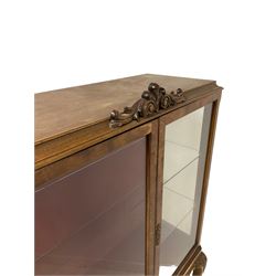 Mid-20th century walnut display cabinet, fitted with two glazed doors, opening to reveal two glass shelves, surmounted by scrolled pediment, raised on cabriole supports with acanthus leaf carving