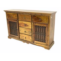 Mexican pine sideboard, fitted with six drawers and two cupboards with wrought metal panels, raised on shaped plinth base W149cm
