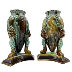 Pair of Victorian Majolica vases, each of tapered form, supported by three lion mask and paw feet, on trefoil stepped base, H23cm