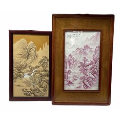 20th century Chinese porcelain plaque hand painted with a mountainous river landscape in pink, within hardwood frame, 50cm x 29cm together with another 20th century Chinese porcelain plaque painted with a similar subject, both signed (2)