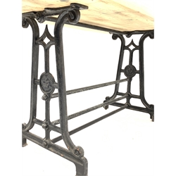 19th century industrial cast iron table, scrolled end supports united by three stretchers stamped 'The Crown', one side raised on castors, with a later solid pine top, 134cm x 70cm, H80cm