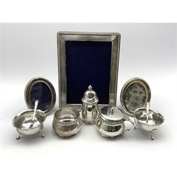 Silver circular three piece condiment set Birmingham 1955, pair of Victorian silver salts London 1895, pair of small oval silver photograph frames and an upright frame 