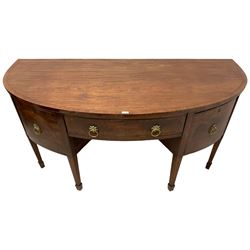 George III mahogany demi-lune sideboard, the crossbanded top over three drawers and flanking cupboards, the facias with figured panels and foliage cast gilt metal handle plates, on square tapering supports with spade feet